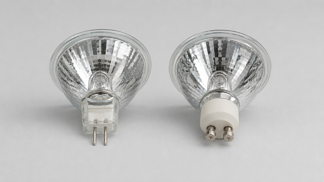 Two MR16 reflector bulbs side by side with identical fronts but different bases — a GU5.3 two-pin base and a GU10 twist-lock base — showing how to tell low-voltage and line-voltage bulbs apart.